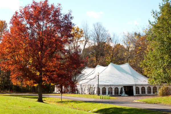 Large white party tent setup outdoors on a clear day