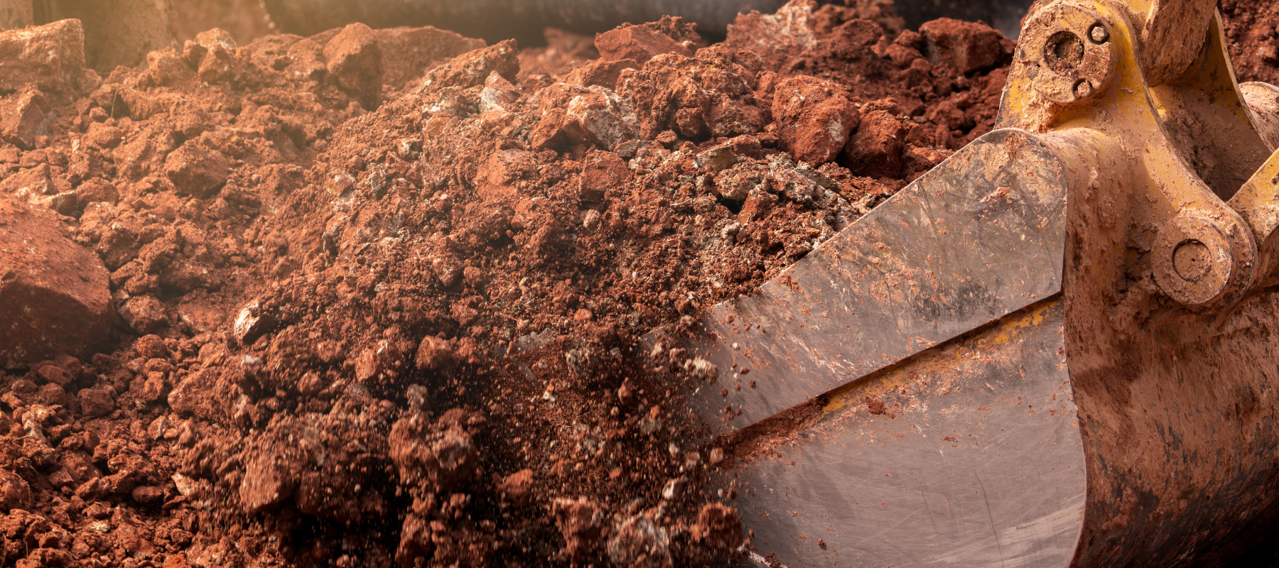 Loader bucket moving dirt